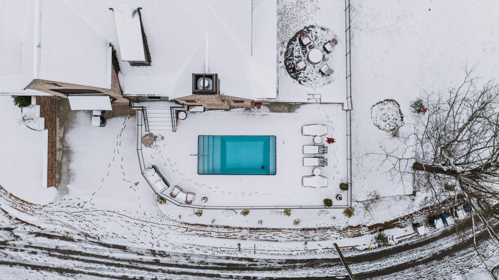 Backyard pool surrounded by snow