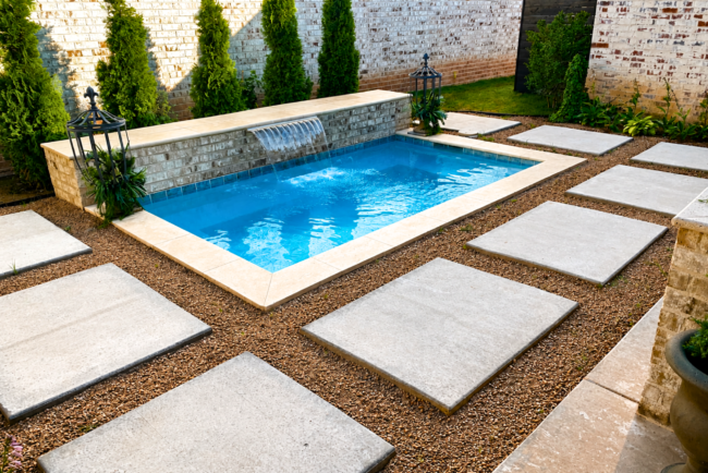 Custom Plunge Pool Builder in Amarillo, TX Custom plunge pool with a raised sheer descent waterfall, premium stone coping, and modern landscaping built for a backyard in Amarillo, Texas.
