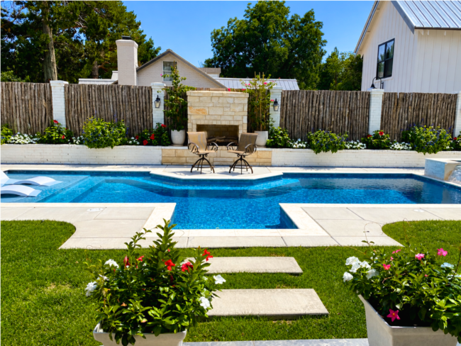 Custom Backyard Pool Construction in Amarillo, TX Custom inground swimming pool with tanning ledge, built-in fireplace, premium landscaping, and luxury outdoor living space in Amarillo, Texas.