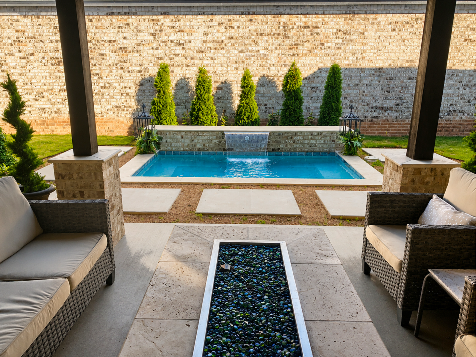 Custom plunge pool with a raised sheer descent waterfall, covered patio, and modern outdoor living space in Amarillo, Texas.